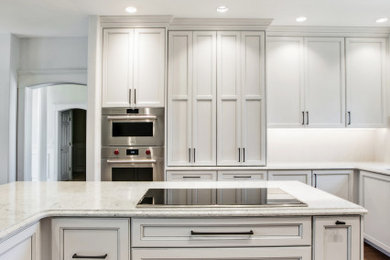 Large trendy u-shaped eat-in kitchen photo in Seattle with shaker cabinets, white cabinets, quartz countertops, an island and white countertops