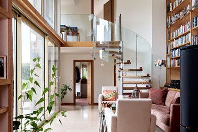 Photo of a small contemporary wood spiral glass railing staircase in Wiltshire with open risers and feature lighting.
