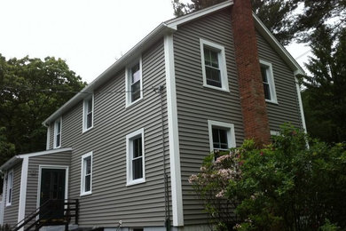 Example of a large classic gray three-story wood gable roof design in New York