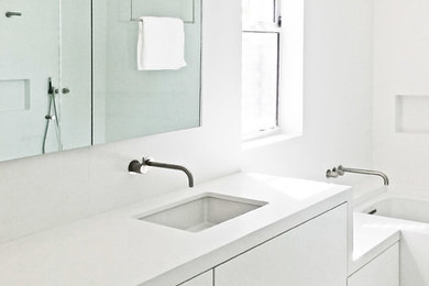 Inspiration for a mid-sized contemporary master white tile and stone slab white floor doorless shower remodel in Los Angeles with flat-panel cabinets, white cabinets, an undermount tub, a two-piece toilet, white walls, an undermount sink, solid surface countertops and a hinged shower door