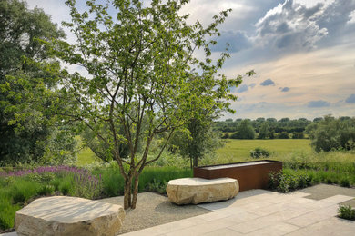 Modelo de jardín moderno de tamaño medio en patio trasero con adoquines de piedra natural