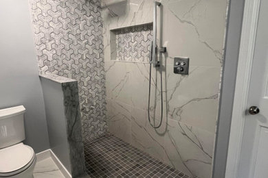 Inspiration for a mid-sized transitional master gray tile and porcelain tile porcelain tile, multicolored floor and double-sink bathroom remodel in DC Metro with flat-panel cabinets, gray cabinets, gray walls, an undermount sink, quartz countertops, white countertops and a floating vanity