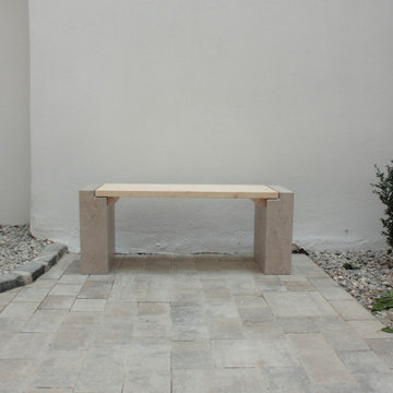 Bank aus Naturstein und Holz in einem Innenhof