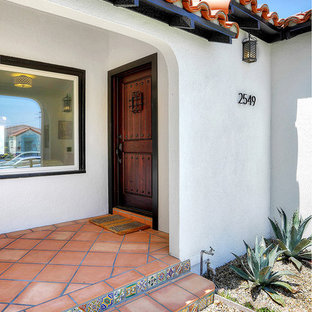 Foto di una porta d'ingresso mediterranea con pavimento in terracotta e una porta singola
