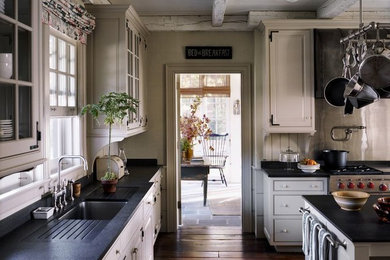 Large farmhouse u-shaped medium tone wood floor and brown floor enclosed kitchen photo in New York with an undermount sink, raised-panel cabinets, white cabinets, white backsplash, wood backsplash, stainless steel appliances, an island and quartz countertops
