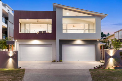 This is an example of a large beach style front door in Gold Coast - Tweed with white walls, concrete floors, a single front door, a medium wood front door and grey floor.