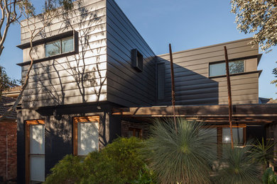 Design ideas for a contemporary two-storey black exterior in Melbourne with metal siding.