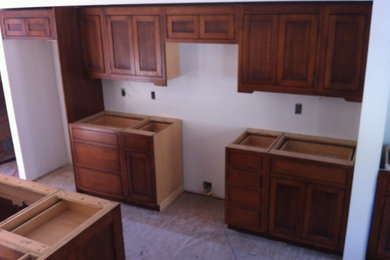 Imagen de cocina de estilo de casa de campo con armarios estilo shaker, puertas de armario de madera en tonos medios y una isla