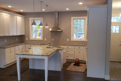 Mid-sized elegant u-shaped dark wood floor and brown floor open concept kitchen photo in Other with an undermount sink, recessed-panel cabinets, white cabinets, granite countertops, stainless steel appliances, an island and gray countertops