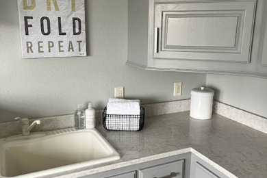 Ejemplo de lavadero clásico renovado con fregadero encastrado, paredes grises, lavadora y secadora juntas y encimeras beige