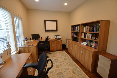 Diseño de despacho clásico renovado pequeño con paredes beige, suelo laminado, escritorio independiente y suelo marrón