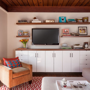 This is an example of a small midcentury open plan home cinema in San Francisco with white walls, dark hardwood flooring and a wall mounted tv.
