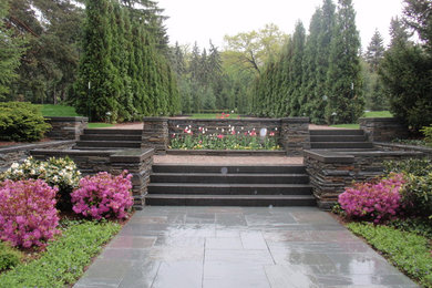 Photo of a large arts and crafts backyard full sun formal garden for spring in Detroit with a garden path and concrete pavers.