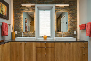 Large minimalist master gray tile and porcelain tile porcelain tile corner shower photo in Other with a vessel sink, flat-panel cabinets, light wood cabinets, quartzite countertops, a one-piece toilet and blue walls