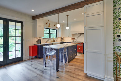 This is an example of a l-shaped eat-in kitchen in Seattle with a farmhouse sink, white cabinets, marble benchtops, white splashback, marble splashback, medium hardwood floors, with island and white benchtop.