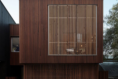 Design ideas for a mid-sized contemporary three-storey brown house exterior in Melbourne with wood siding, a flat roof and a metal roof.