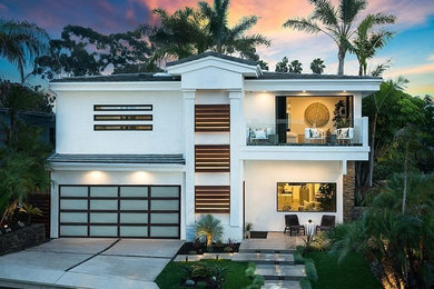 Mid-sized trendy white two-story stucco house exterior photo in Orange County with a tile roof