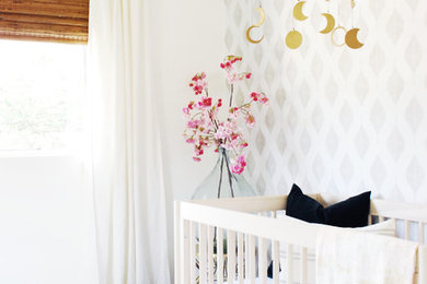 Photo of a transitional nursery in Los Angeles with laminate floors and brown floor.