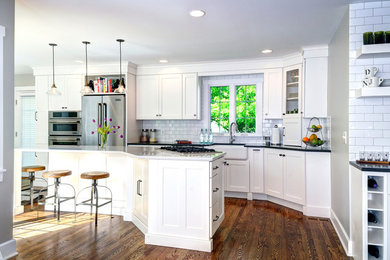 Kitchen - modern kitchen idea in Columbus with a farmhouse sink, white cabinets, white backsplash, stainless steel appliances and an island