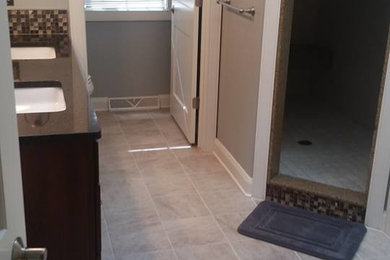 Inspiration for a mid-sized timeless master beige tile, brown tile and glass tile ceramic tile and gray floor bathroom remodel in Phoenix with dark wood cabinets, gray walls, an undermount sink and solid surface countertops