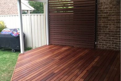 Photo of a modern backyard deck in Sydney with a pergola.