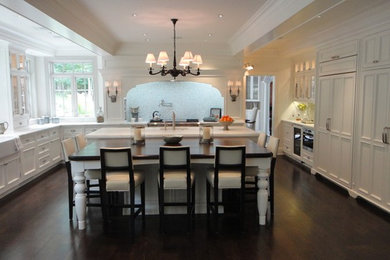 Inspiration for a huge transitional u-shaped dark wood floor eat-in kitchen remodel in St Louis with an undermount sink, recessed-panel cabinets, white cabinets, marble countertops, paneled appliances and an island