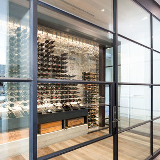 Inspiration for a large modern wine cellar in Sacramento with medium hardwood flooring, storage racks and brown floors.