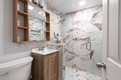 Bathroom - small modern 3/4 beige tile and porcelain tile porcelain tile, beige floor and single-sink bathroom idea in Chicago with glass-front cabinets, light wood cabinets, white walls, white countertops, a niche and a floating vanity