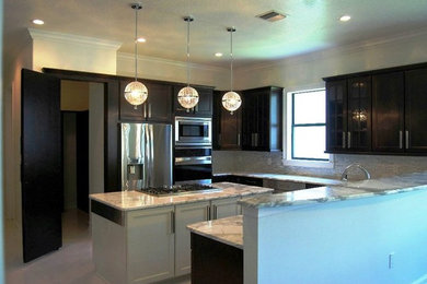 Large trendy u-shaped eat-in kitchen photo in Tampa with raised-panel cabinets, black cabinets, gray backsplash, stainless steel appliances and an island