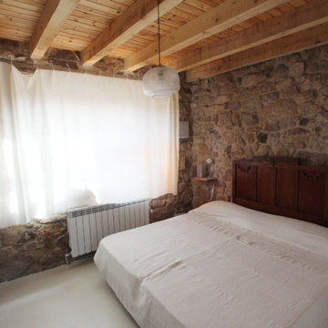 Dormitorio rústico con fachada de piedra