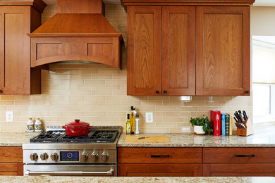 Example of a mid-sized classic medium tone wood floor eat-in kitchen design in DC Metro with flat-panel cabinets, medium tone wood cabinets, beige backsplash, subway tile backsplash, stainless steel appliances and an island