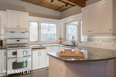 Transitional u-shaped medium tone wood floor and brown floor eat-in kitchen photo in Other with an undermount sink, shaker cabinets, white cabinets, multicolored backsplash, ceramic backsplash, white appliances and an island