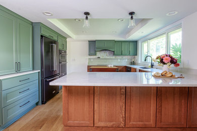 Inspiration for a mid-sized transitional u-shaped brown floor and tray ceiling eat-in kitchen remodel in Portland with a single-bowl sink, green cabinets, quartz countertops, white backsplash, stainless steel appliances, an island and white countertops