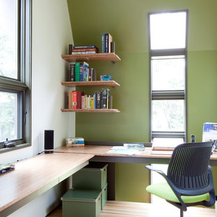 Inspiration for a modern home office and library in Nashville with green walls, medium hardwood flooring, a built-in desk and beige floors.
