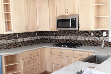 Inspiration for a large timeless u-shaped kitchen remodel in Other with a farmhouse sink, shaker cabinets, light wood cabinets, quartz countertops, multicolored backsplash, glass tile backsplash and white countertops