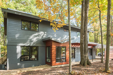 Inspiration for a mid-sized contemporary gray three-story brick gable roof remodel in Charlotte