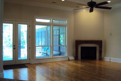 ダラスにある広いトラディショナルスタイルのおしゃれなLDK (ベージュの壁、淡色無垢フローリング、標準型暖炉、テレビなし、茶色い床、折り上げ天井) の写真