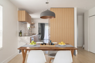 Inspiration for a mid-sized modern light wood floor kitchen/dining room combo remodel in Vancouver with white walls