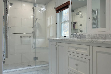 Bathroom - mid-sized transitional master white tile and ceramic tile marble floor, gray floor and double-sink bathroom idea in Boston with recessed-panel cabinets, white cabinets, a one-piece toilet, white walls, an undermount sink, marble countertops, a hinged shower door, gray countertops and a built-in vanity