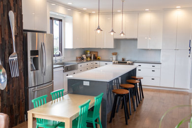 Trendy l-shaped eat-in kitchen photo in Other with a farmhouse sink, flat-panel cabinets, white cabinets, quartz countertops, white backsplash, ceramic backsplash, stainless steel appliances, an island and gray countertops