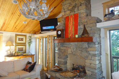 Living room - small rustic open concept medium tone wood floor living room idea in Little Rock with white walls, a standard fireplace, a stone fireplace and a tv stand