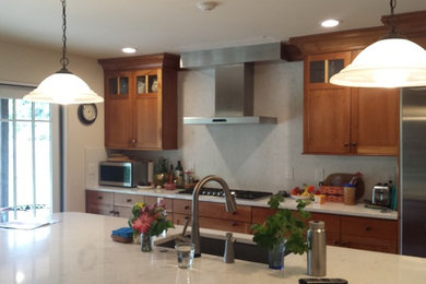 Inspiration for a mid-sized contemporary single-wall light wood floor kitchen remodel in Denver with an undermount sink, shaker cabinets, medium tone wood cabinets, quartzite countertops, white backsplash, stone tile backsplash, stainless steel appliances and an island
