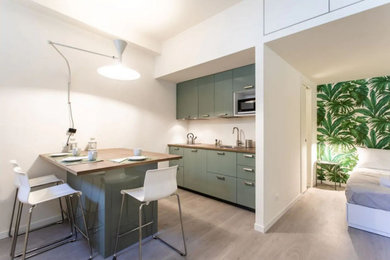 Esempio di una cucina tropicale con lavello a vasca singola, ante a filo, ante verdi, top in laminato, pavimento in laminato e top marrone