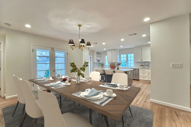 Example of a cottage / country u-shaped eat-in kitchen design with a drop-in sink, shaker cabinets, white cabinets, quartzite countertops, blue backsplash, ceramic backsplash, stainless steel appliances, an island and white countertops