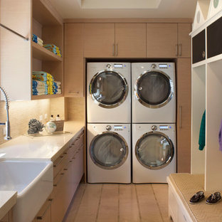 ロサンゼルスのトラディショナルスタイルのおしゃれなランドリールーム (エプロンフロントシンク、淡色木目調キャビネット、上下配置の洗濯機・乾燥機) の写真
