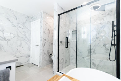Example of a mid-sized trendy master black and white tile and porcelain tile porcelain tile, gray floor and double-sink bathroom design in Ottawa with shaker cabinets, white cabinets, white walls, an undermount sink, quartz countertops, gray countertops, a niche and a built-in vanity