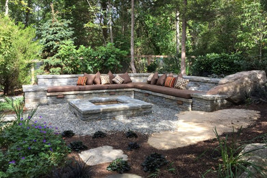 This is an example of a large contemporary backyard garden in Bridgeport with a fire feature and natural stone pavers.