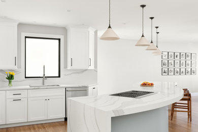 Eat-in kitchen - large transitional l-shaped light wood floor eat-in kitchen idea in San Francisco with an undermount sink, shaker cabinets, white cabinets, quartzite countertops, white backsplash, quartz backsplash, stainless steel appliances, an island and white countertops