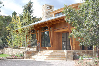 This is an example of a large country two-storey brown exterior in Denver with wood siding.