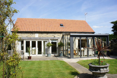 This is an example of a small traditional two floor detached house in Other with stone cladding and a pitched roof.